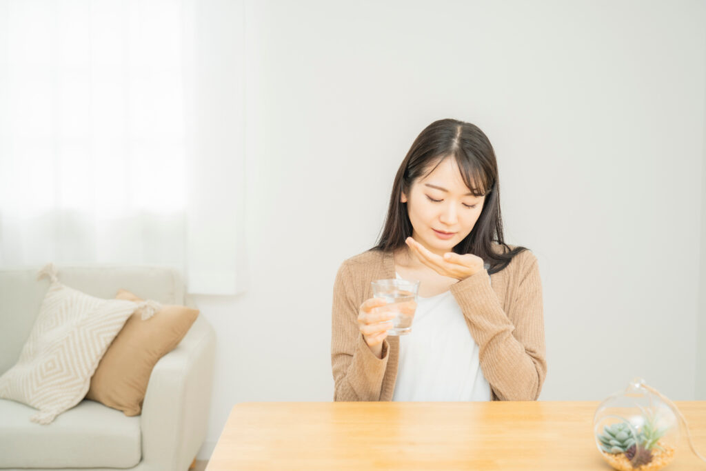 薬を飲む女性
