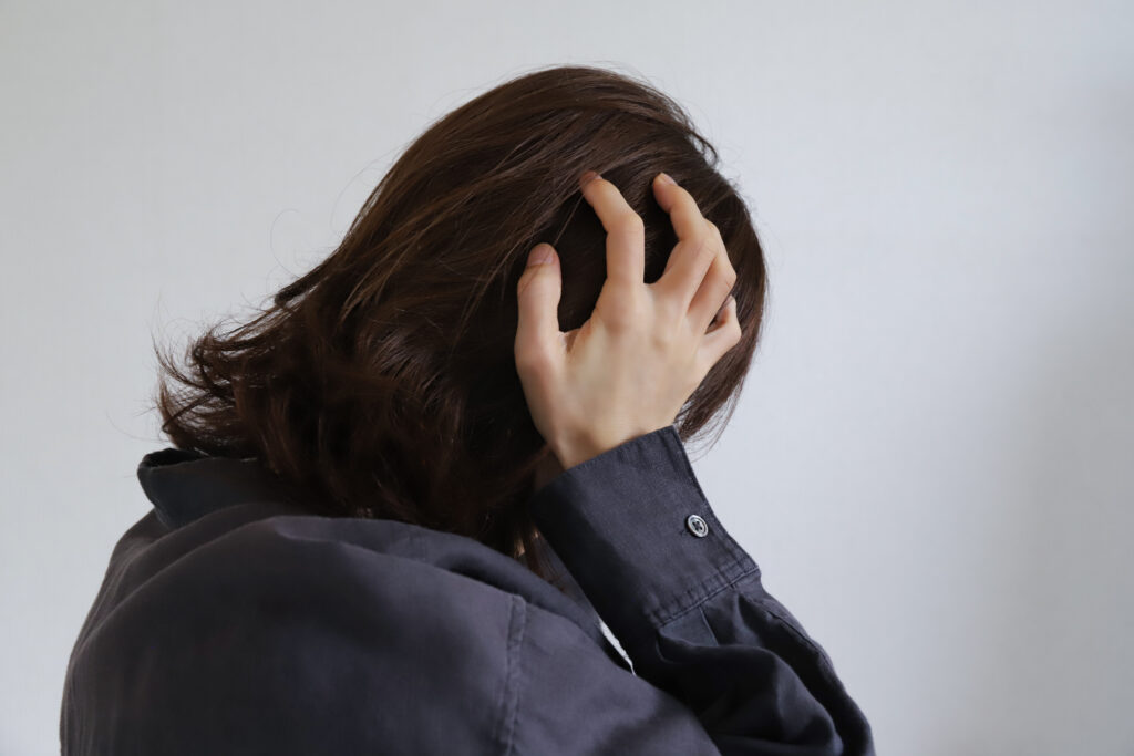 頭を抱える女性　悩みイメージ