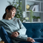 ソファで落ち込む女性